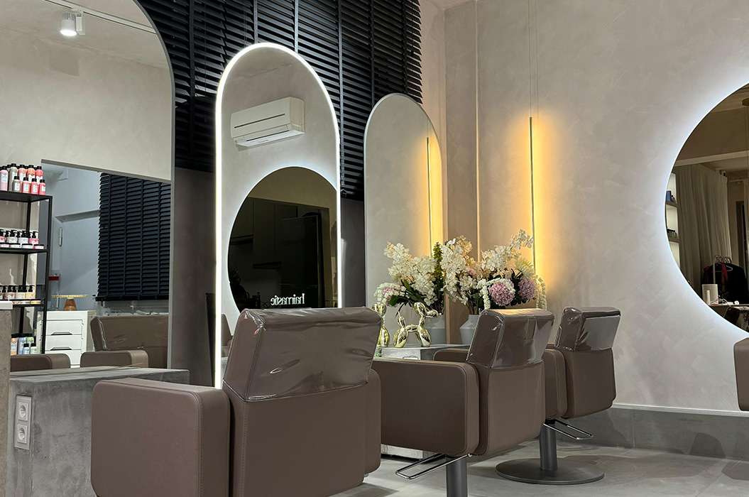 Moderner Salon in Grau mit braunen Stuehlen und Blumenarrangement