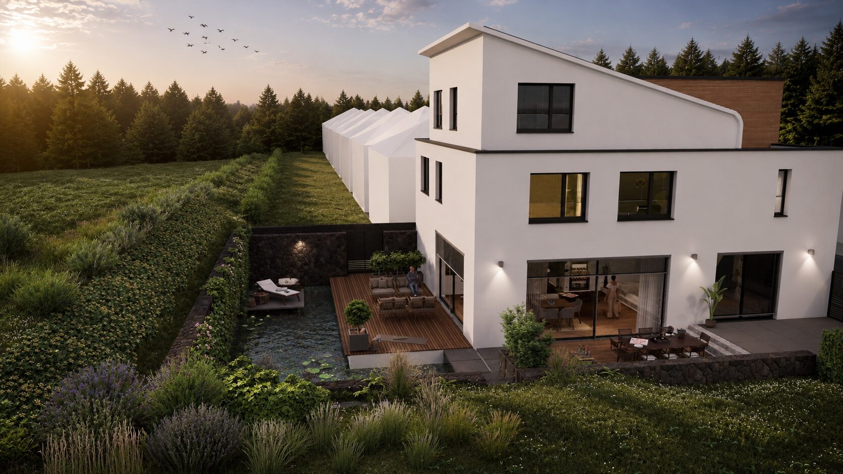 Modernes weisses Haus mit Terrasse und Teich am Waldrand bei Sonnenuntergang